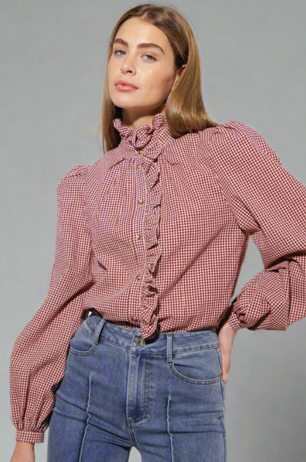 This button up top has puff sleeves and a front ruffle detail. It is a burgundy checkered pattern.