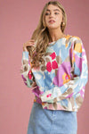 A lightweight ivory sweater with a colorful abstract pattern. It is mid length with long sleeves.