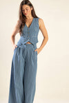 These high waisted, wide leg pants have a pleated front and button waist. The denim has vertical white stripes.