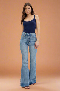 A pair of women’s high-waisted flare leg jeans by Judy Blue with a unique released hem and vintage light wash.