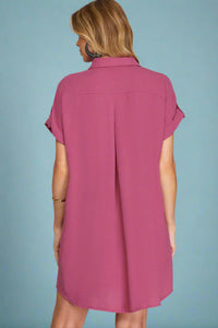 Woman wearing a pink dress against a plain background
