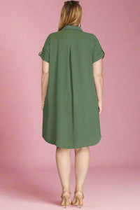 Woman wearing a green dress against a plain background