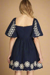 Navy blue dress with white floral embroidery on a plain background