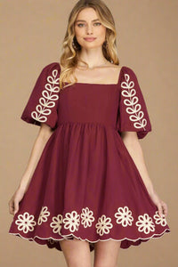 Maroon dress with floral and leaf patterns on a plain background