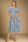 Woman wearing a blue and white patterned dress on a plain background