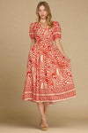 Woman wearing a red and white patterned dress on a plain background