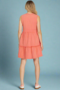 Woman wearing a coral dress on a plain background