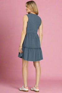 Woman wearing a blue dress on a plain background.