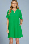 Woman wearing a green dress against a plain background.