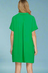 Green dress worn by a person on a plain background.