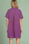 Purple dress worn by a person on a plain background.