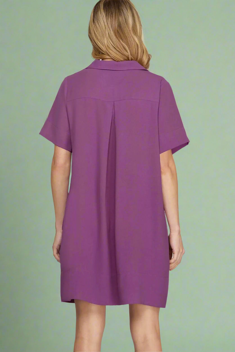 Purple dress worn by a person on a plain background.