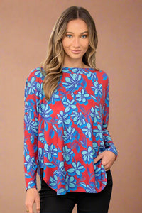 Women’s lightweight long sleeve top with red and blue floral print featuring scoop hem, slight dolman sleeve, boat neckline  and v cutout in back.