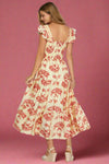 Woman wearing a floral dress with red flowers on a plain background