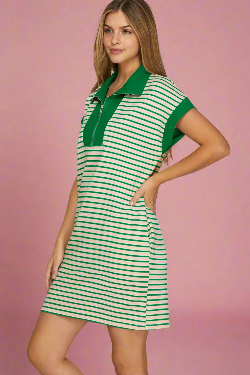 Woman wearing a green and white striped dress on a plain background