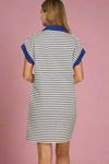 Woman wearing a striped dress with blue accents on a plain background