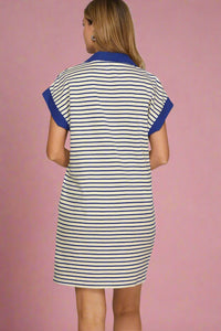Woman wearing a striped dress with blue accents on a plain background