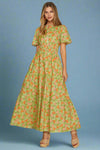 Woman wearing a green floral dress on a plain background
