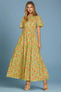 Woman wearing a green floral dress on a plain background