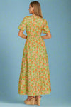 Woman wearing a green floral dress on a plain background