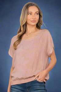 A relaxed fit mauve top. It has unique short sleeves and a ribbed waist bad.