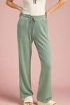 These high waist drawstring pants are in a sage green color. They are super soft lounge pants with pockets.