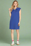 Woman wearing a blue sleeveless dress on a plain background