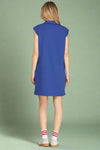 Woman wearing a blue sleeveless dress on a plain background