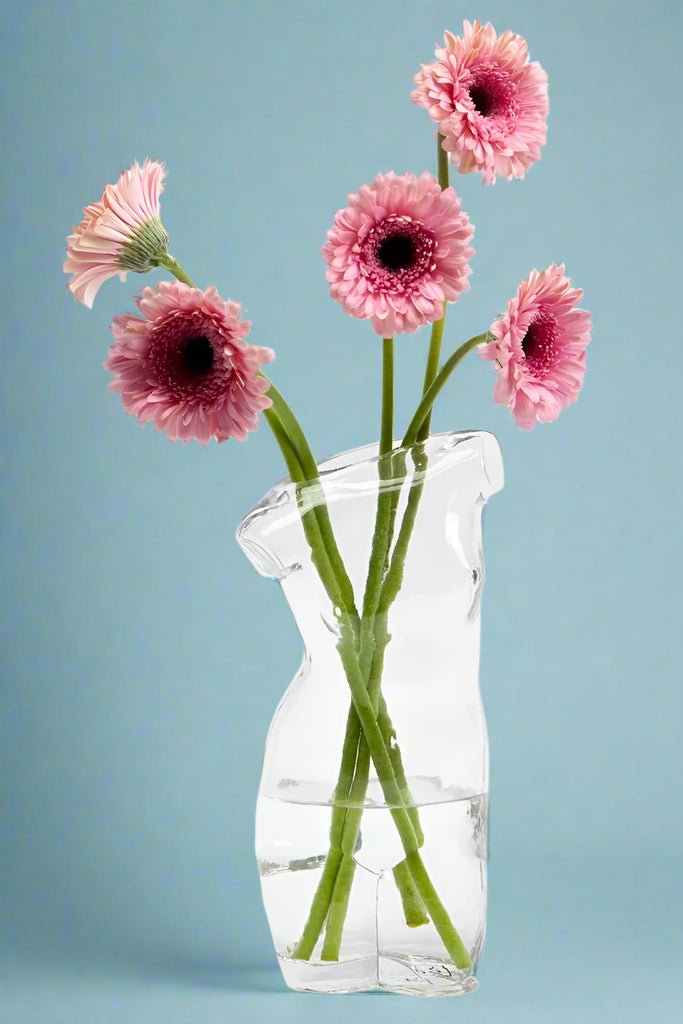 A clear glass vase in the shape of a woman’s body from shoulders to thighs.