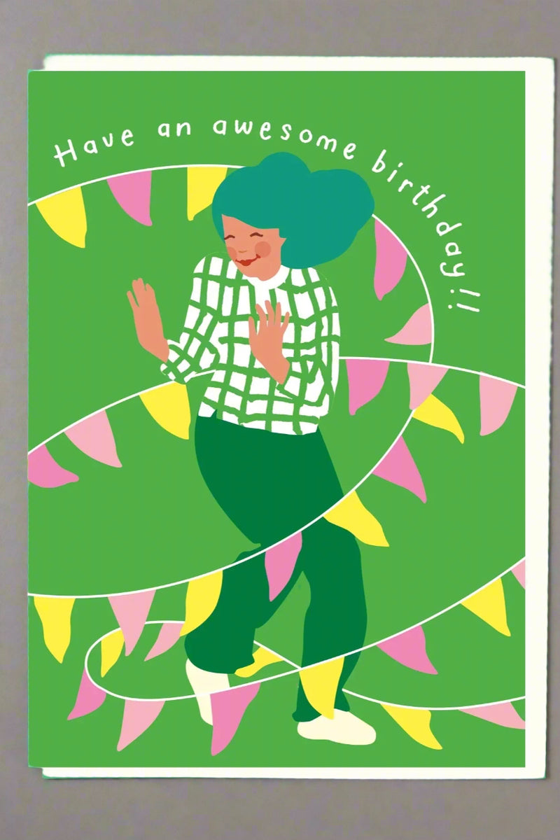 A greeting card with the image of a woman wrapped in a colorful pennant banner and text that reads ‘Have an awesome birthday!!’