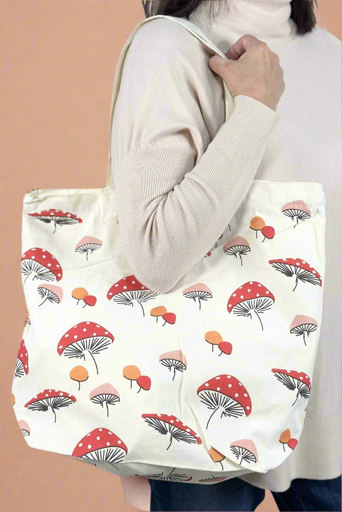 A mushroom pattern tote bag with a zip closure.