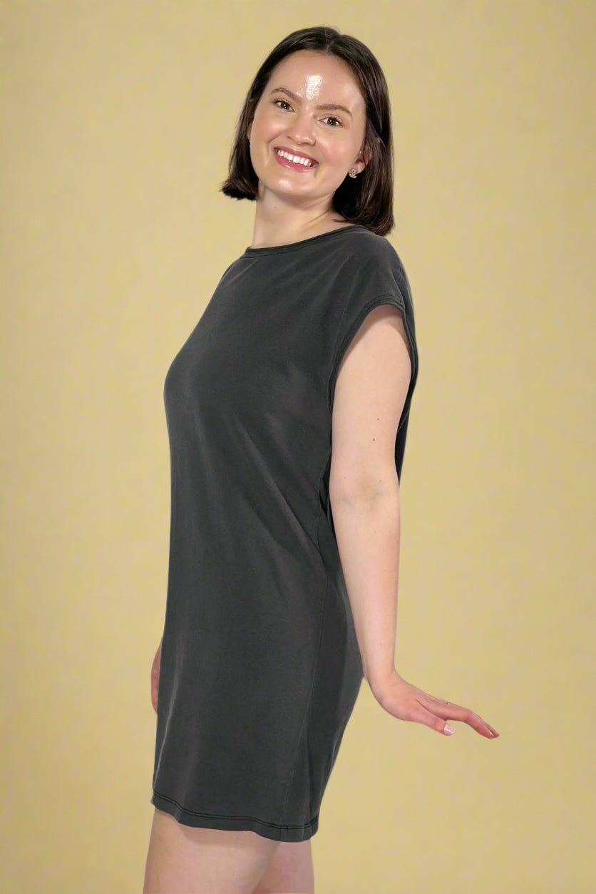 Model is wearing a sleeveles black mini dress. 
