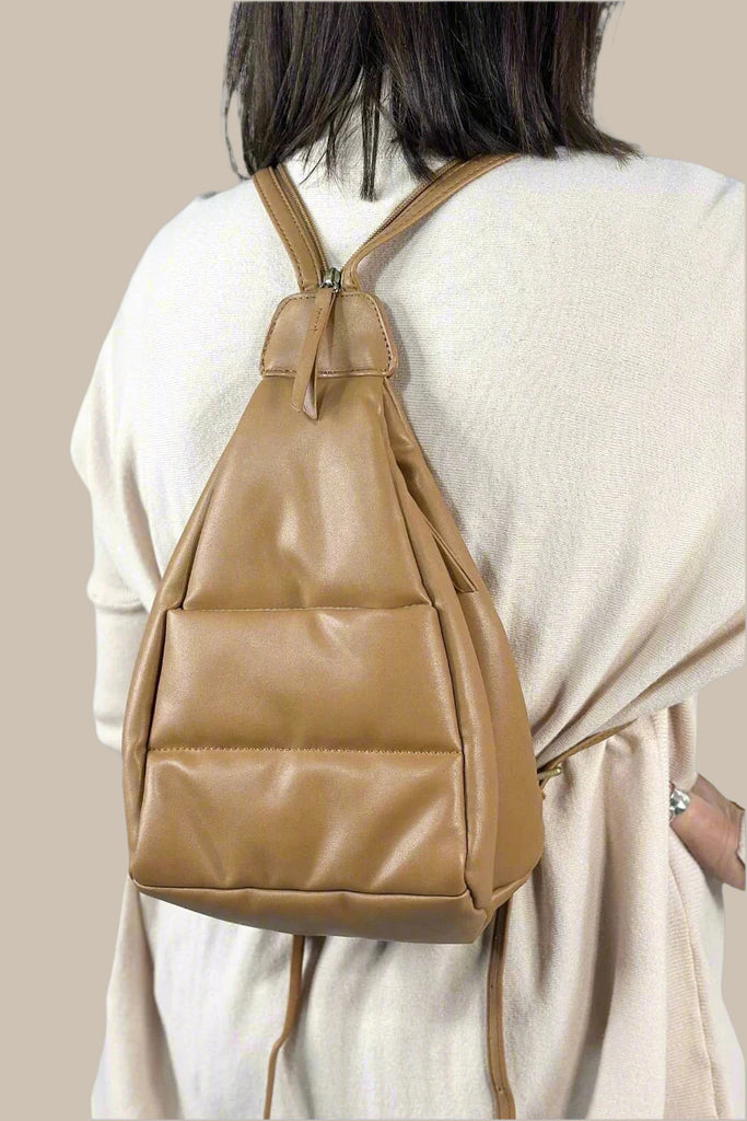 Versatile bag that can be worn as a backpack or slung over your shoulder with the straps zipped up. Featuring a warm tan hue, a quilted design and adjustable handles.