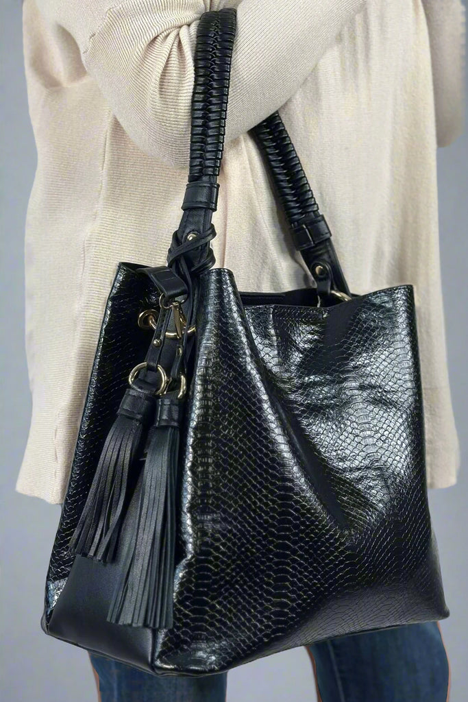 A black snake print hobo bag. Made from vegan l and has a tassel accent.