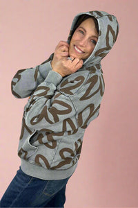 A women’s long sleeve zip up hoodie in washed blue color featuring bold floral print in brown.