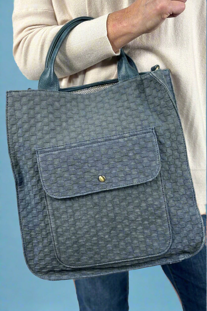 A blue woven satchel that comes with crossbody strap.