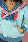 A women’s hooded sweatshirt in a light blue with contrasting knit hood and neckline.