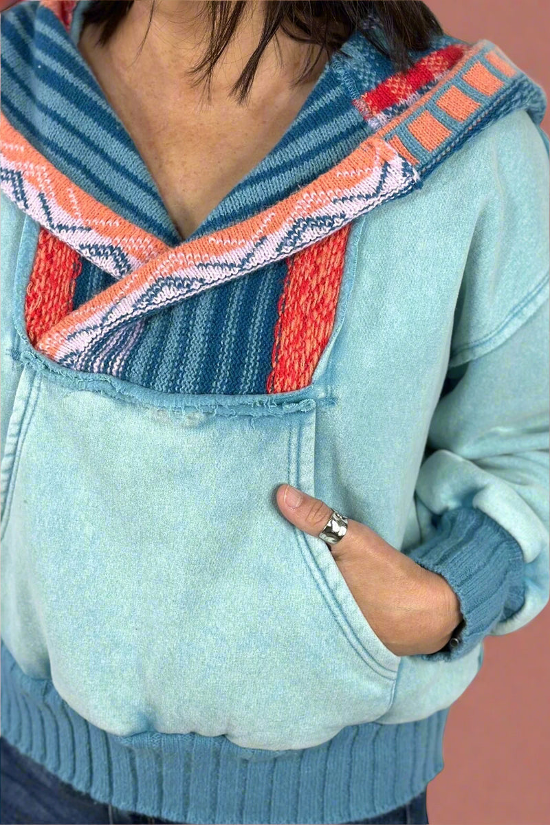A women’s hooded sweatshirt in a light blue with contrasting knit hood and neckline.