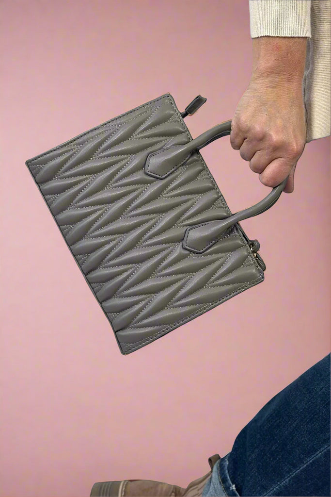 Grey faux leather purse featuring a unique monochrome puffy herringbone pattern for added texture. 