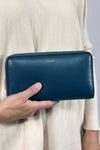 Smooth blueberry colored bubble wallet featuring brushed gold hardware. 