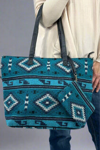 Model is holding a western printed tote bag with an attached wristlet. 