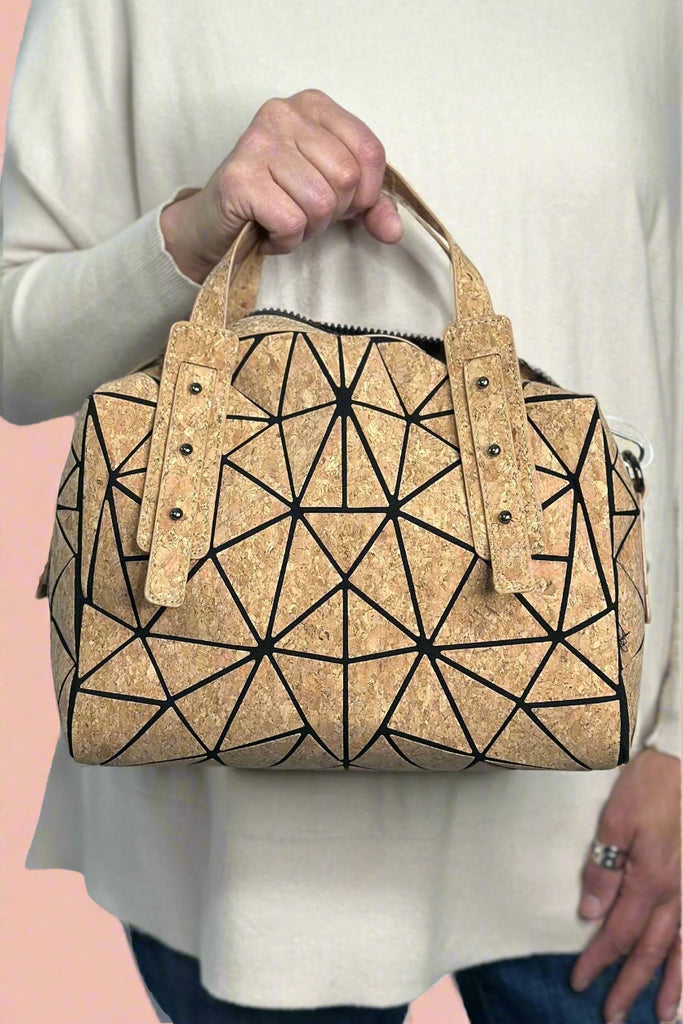 Satchel style purse made of cork featuring geometric lines for added visual texture. Includes a removable cork crossbody strap and top handles. 