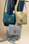 A crossbody bag with a flap and snap closure. Made by New Hope Girls.