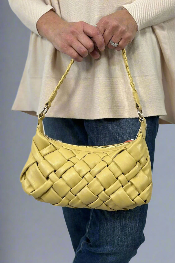 A small lemon colored handbag with a woven pattern and zip enclosure. Includes a crossbody strap.