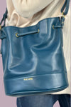 Blueberry colored medium sized bucket bag with adjustable an crossbody strap and a cinch top. Vegan leather with a beautiful soft feel. 