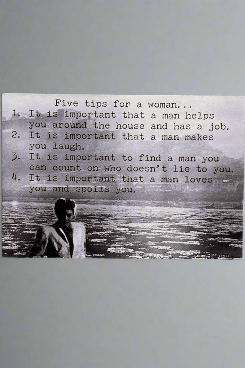 Black and white card with the words “Five tips for a woman…It is important that a man helps you around the house and has a job. It is important that a man makes you laugh. It is important to find a man you can count on who doesn't lie to you. It is important that a man loves you and spoils you.”