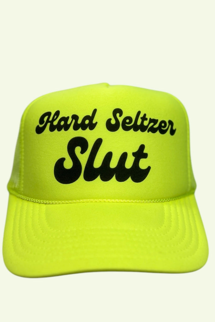 Neon yellow foam front trucker hat with the phrase "Hard Seltzer Slut" printed across the front panel. 