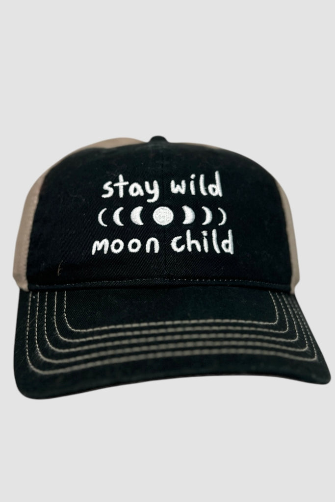 Black and white vintage style trucker hat with the phrase "stay wild moon child" printed across the front panel. 