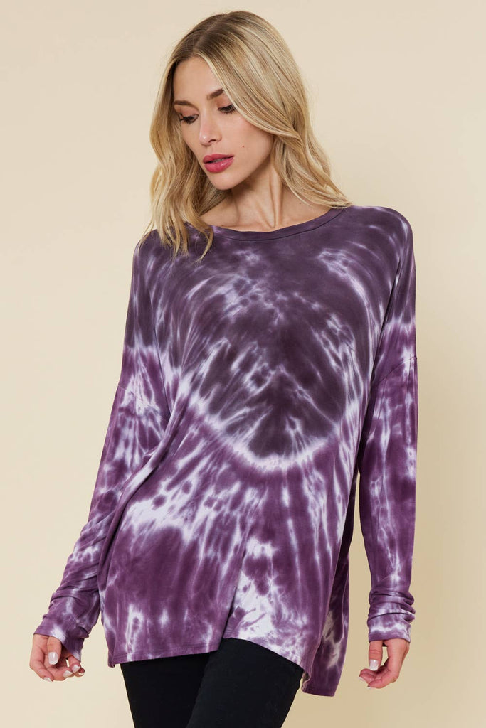 Model is wearing a lightweight long sleeve purple shirt with a unique tie dye pattern and slight dolman sleeve. 