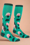 Green socks with pink and black floral pattern on a white background